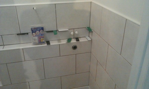 Tiling with holes cut for waste and feed for wash basin